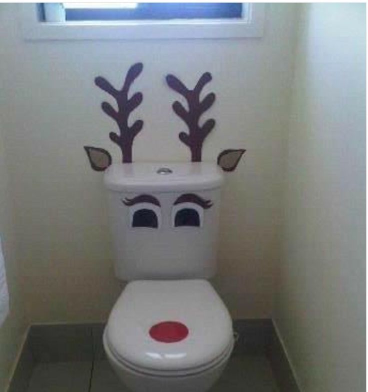 a white toilet with reindeer antlers on it