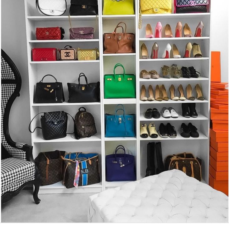 a closet filled with lots of different colored purses and handbags on shelving units