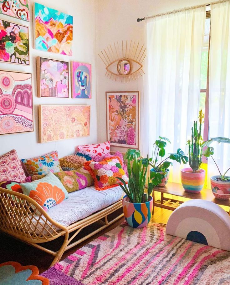 a living room filled with lots of colorful art and plants on the wall next to a couch