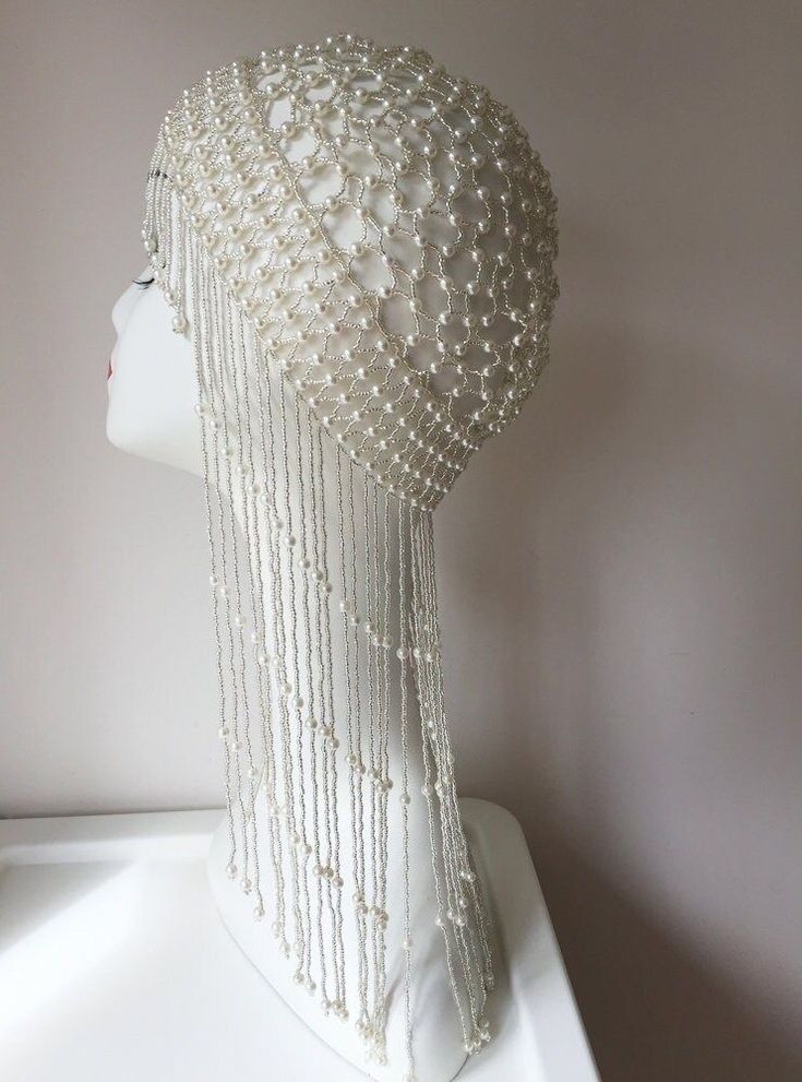 a white mannequin head with pearls on it