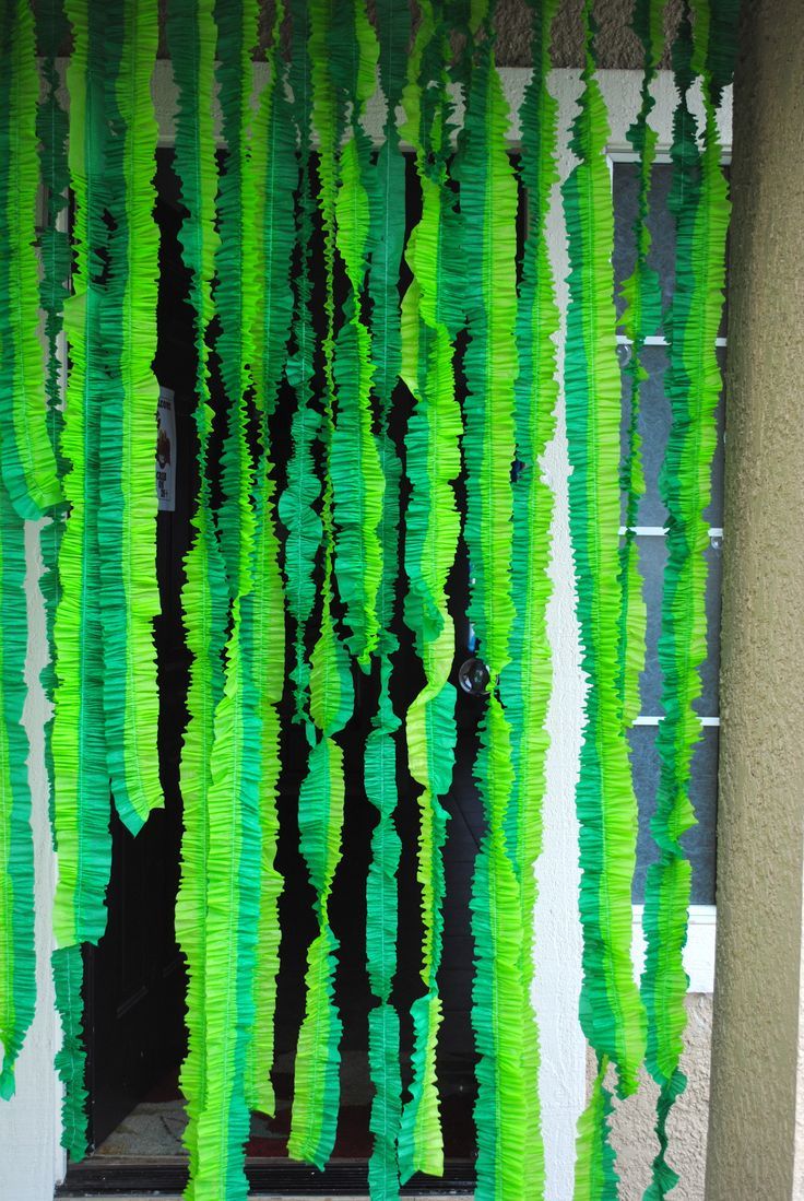 green streamers are hanging from the side of a building in front of a window