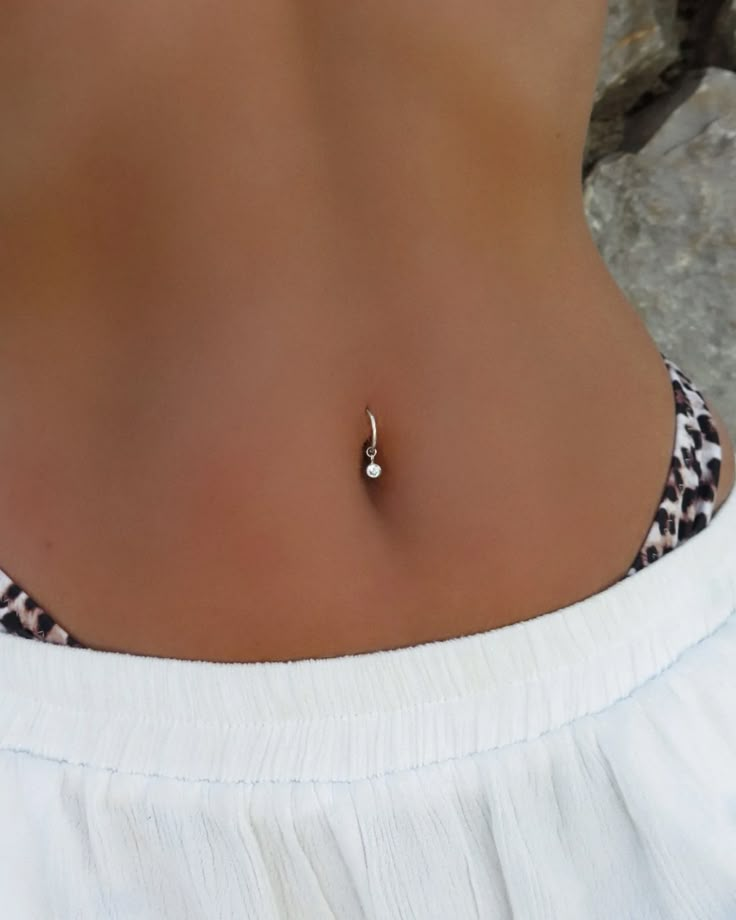 a woman wearing a white top with a gold beaded necklace on her neck and bottom