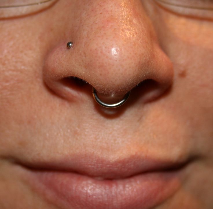 a nose piercing is seen in this close up photo from the front end of a person's nose