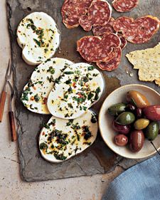 an assortment of appetizers are laid out on a stone slab, ready to be eaten