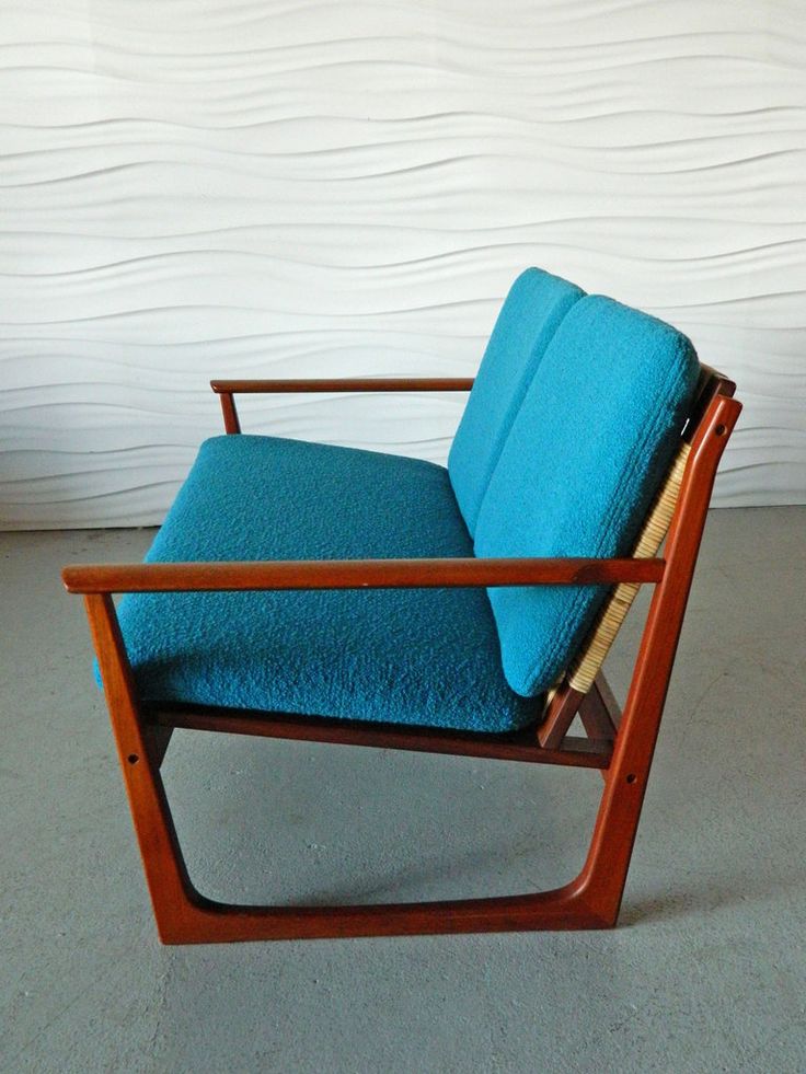 a blue chair sitting in front of a white wall