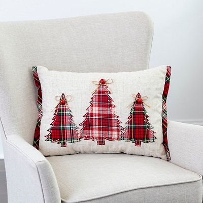 a plaid christmas tree pillow sitting on top of a chair next to a white wall