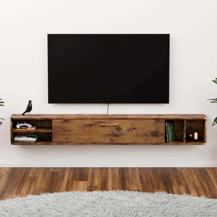 a flat screen tv mounted to the side of a wooden entertainment center in a living room