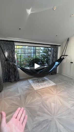 a hammock hanging in the middle of a living room