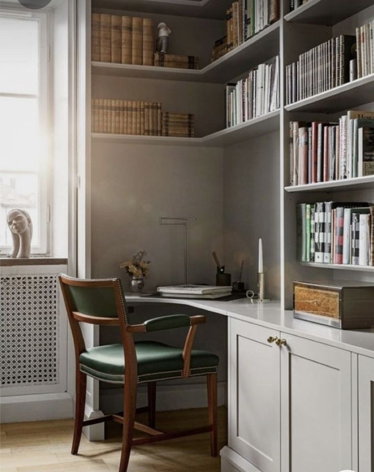 a chair sitting in front of a desk next to a book shelf filled with books