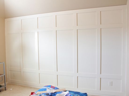 an empty room with white paneling on the walls