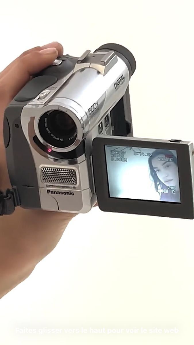 a person holding a video camera in their hand with the screen on it's side