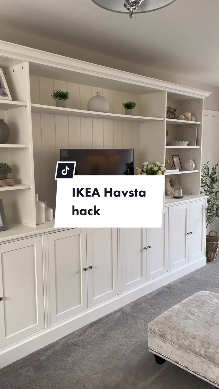 a living room filled with lots of white furniture and bookshelves on top of each other