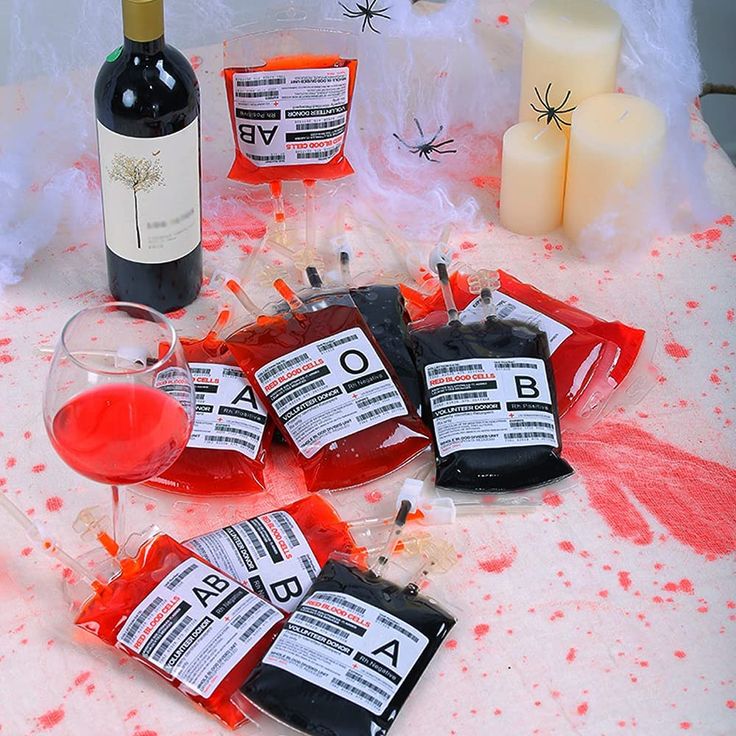 several packets of blood sitting on top of a table next to a bottle of wine