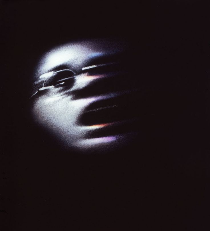 a blurry image of a person's face in the dark with glasses on