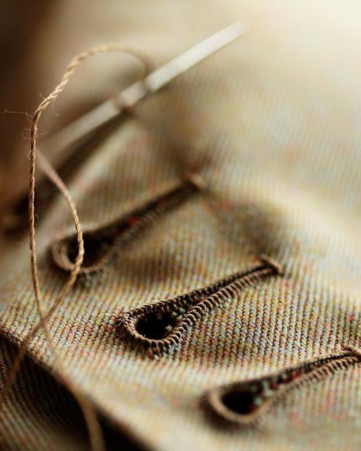 a pair of scissors sitting on top of a piece of cloth next to some thread