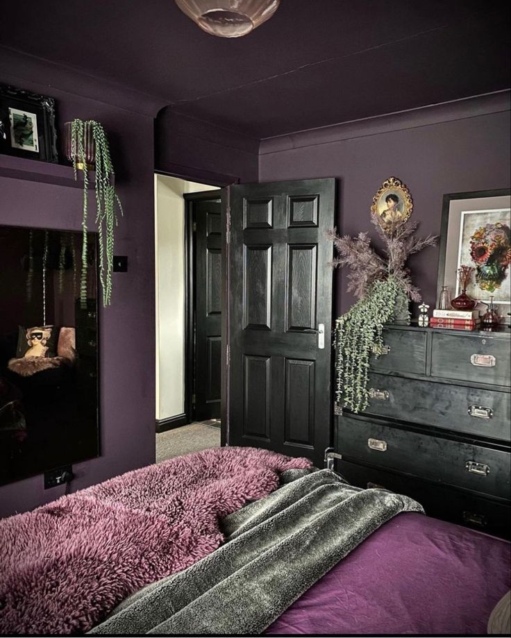 a bedroom with purple walls and black furniture