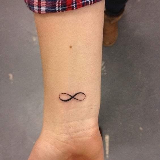 a woman's wrist tattoo with an infinite symbol on it