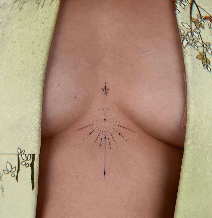 a woman's breast with an arrow tattoo on it