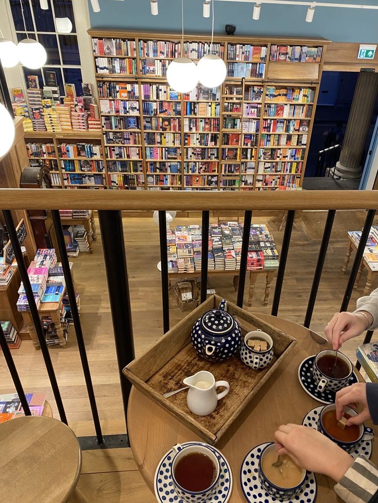 two people sitting at a table with cups of coffee