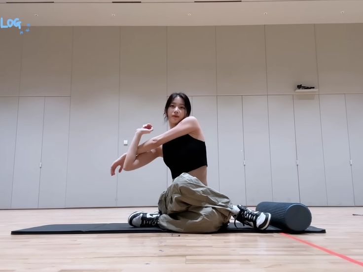 a woman sitting on top of a yoga mat