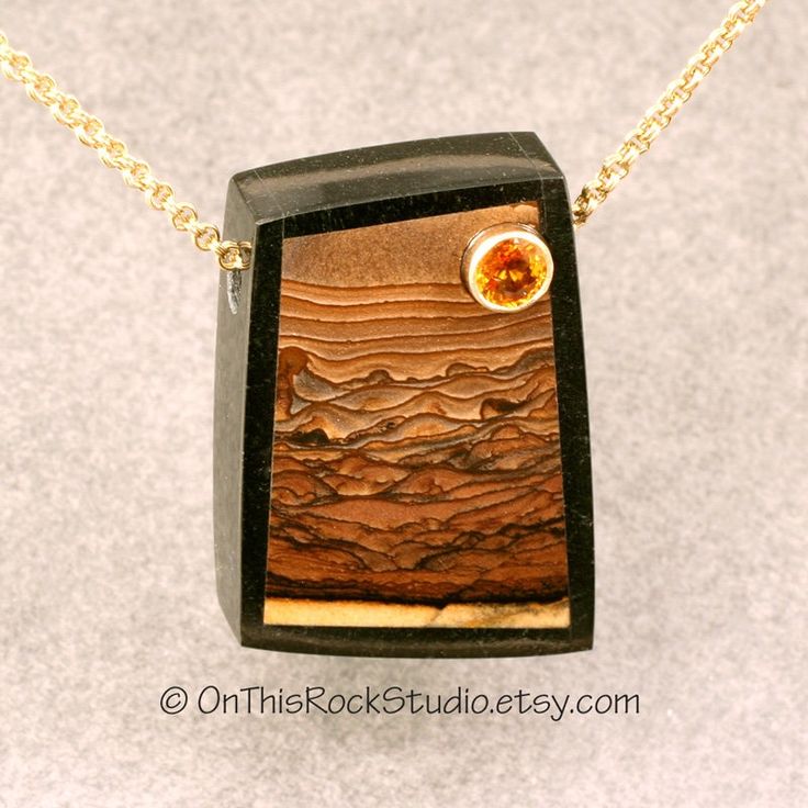 "Dreamy picture of rolling hills in this landscape of natural jasper from Biggs Canyon Oregon.  This pendant shows rich golden browns and tans.  The piece is bordered with black jade from New Zealand.  Set into the sky, in a 14k yellow gold bezel, is a 5mm round genuine orange sapphire.  This is a gorgeous piece of jewelry. The pendant is drilled through the top with a 4 x 3.5mm diameter hole; a size large enough for most chains appropriate to the scale of the pendant.  Leather cord looks great Lapidary Jewelry, Inlay Jewelry, Rock Necklace, Black Jade, Druzy Quartz, Jewelry Stone, Stone Inlay, Orange Sapphire, Picture Jasper