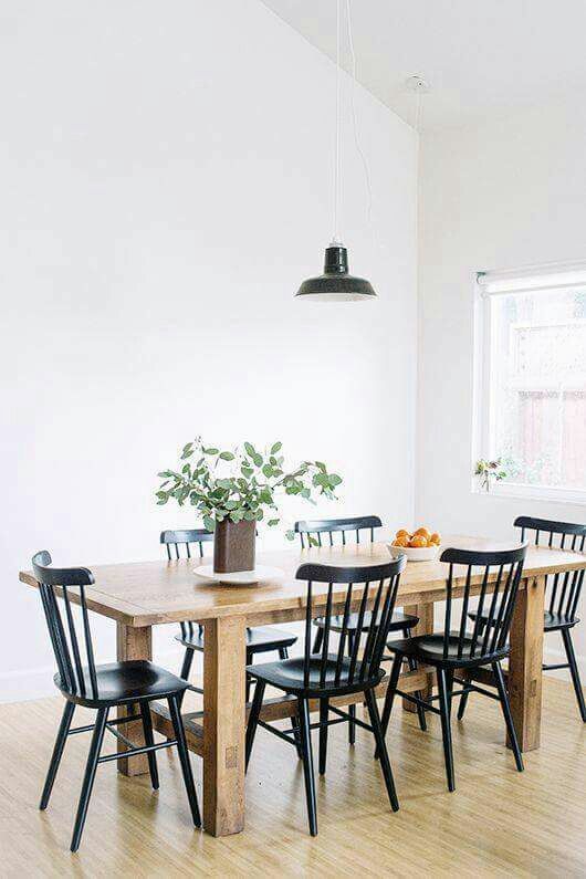 a dining room table with black chairs and a potted plant on the top of it