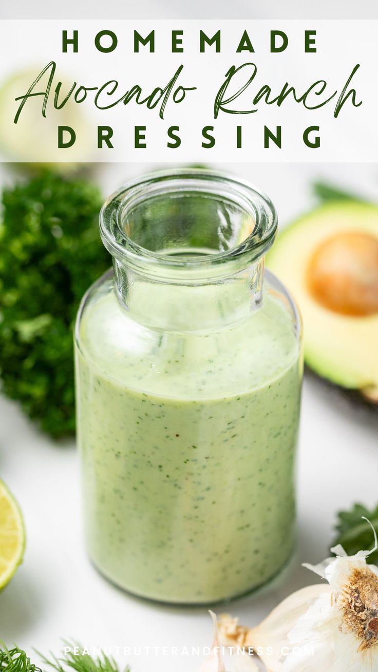 homemade avocado ranch dressing in a glass jar surrounded by fresh vegetables and herbs