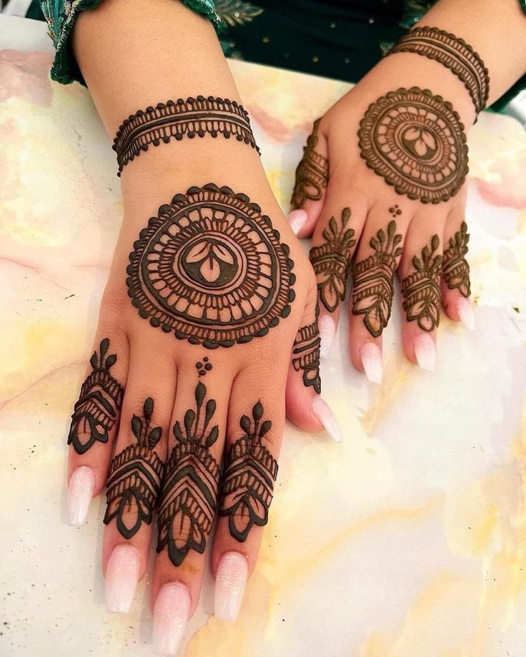 two hands with henna tattoos on them