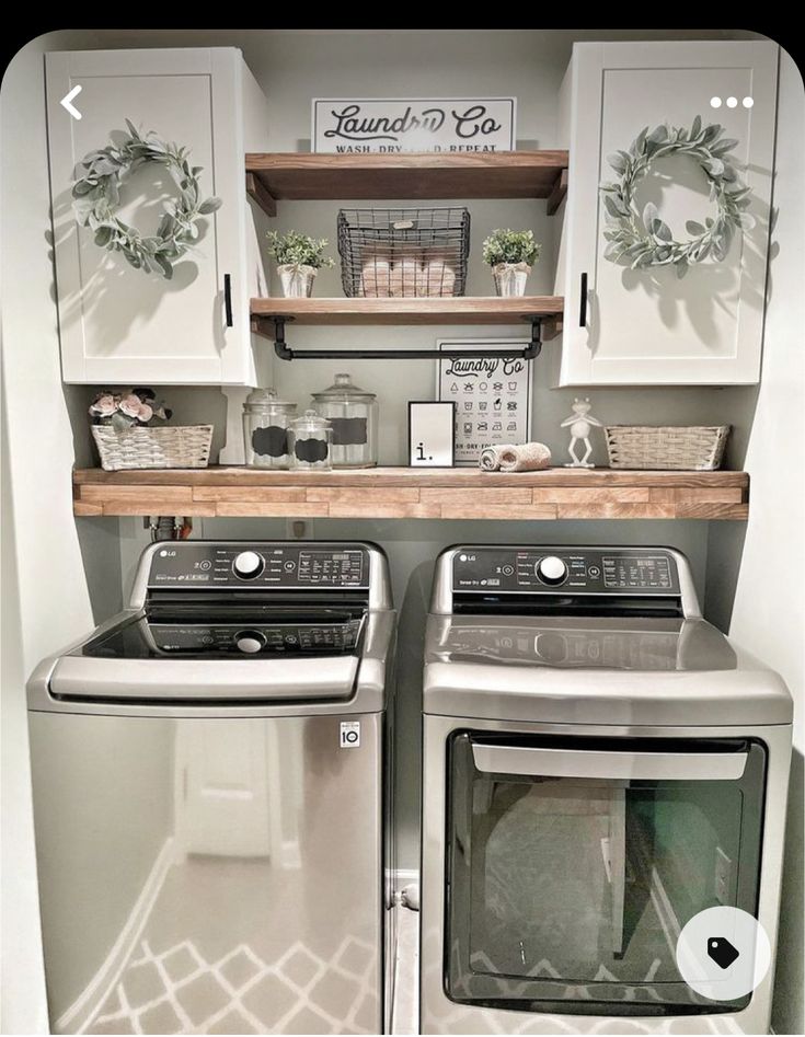 a washer and dryer in a small room with white cabinets on the wall