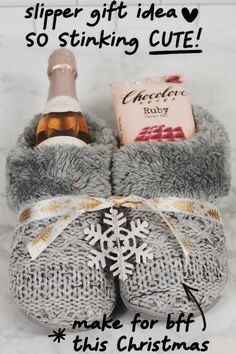 a pair of gray slippers with snowflakes on them and a bottle of wine in the middle