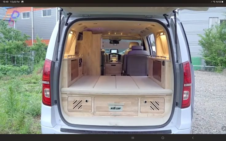 an image of the back end of a van with its doors open and seats folded down