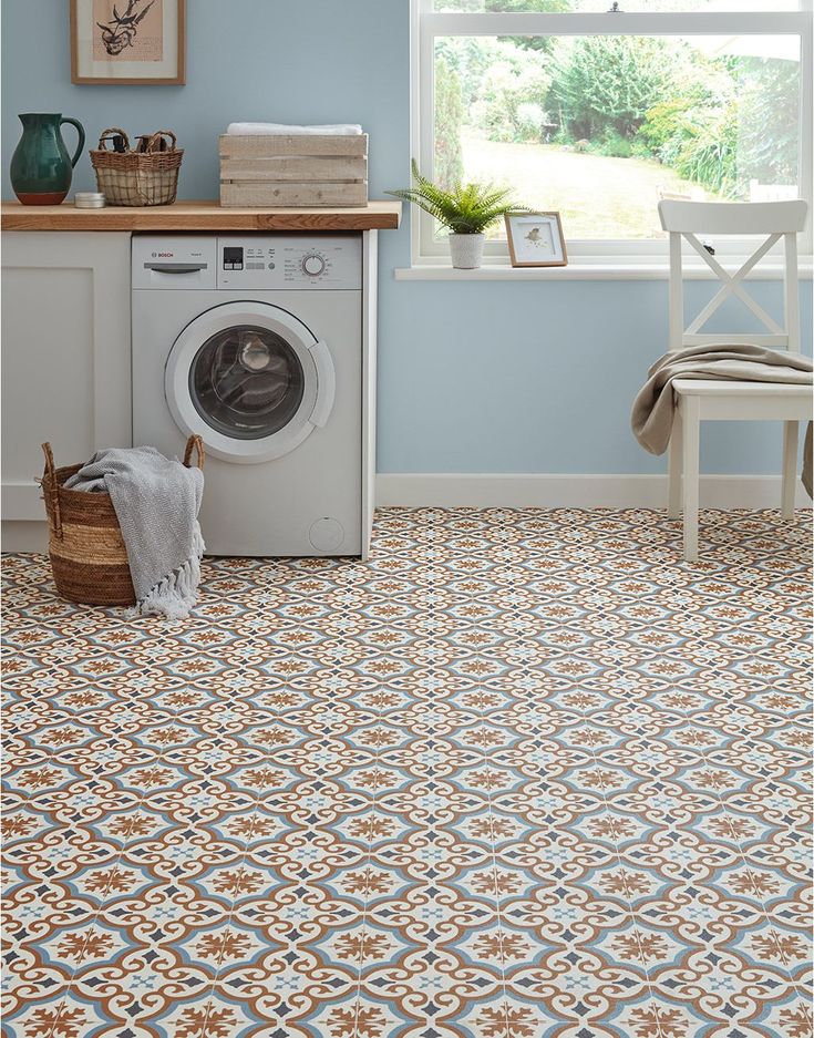 a washer and dryer in a room with blue walls, patterned flooring