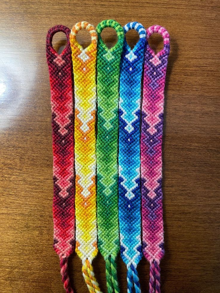 four different colors of beaded hair clips on a table with a light in the background