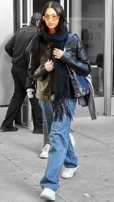 a woman is walking down the street with her hand in her pocket