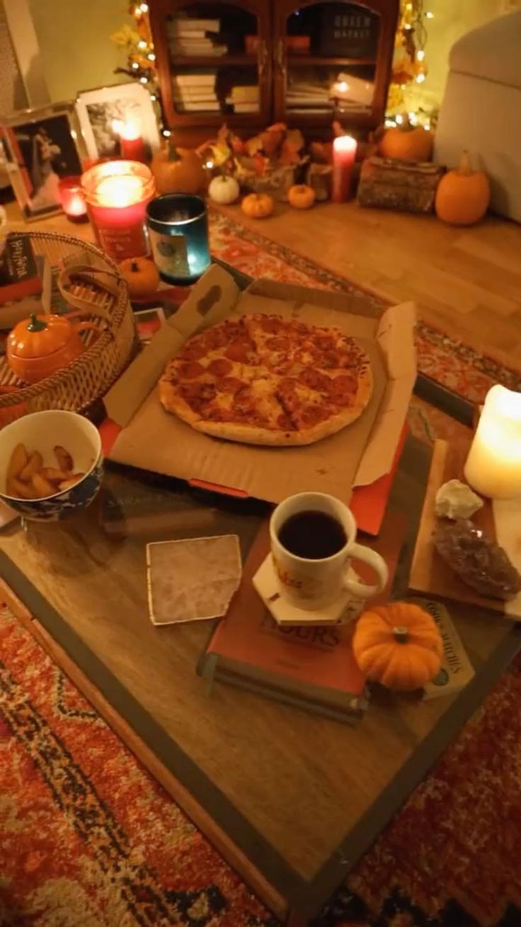 a pizza sitting on top of a wooden table next to a cup and saucer