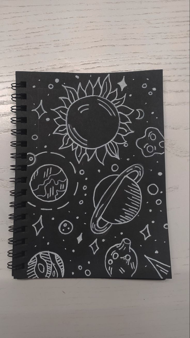 a black notebook with white drawings on it