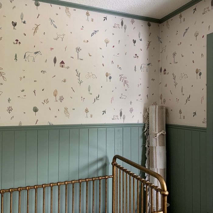 a baby's crib in a room with wallpaper