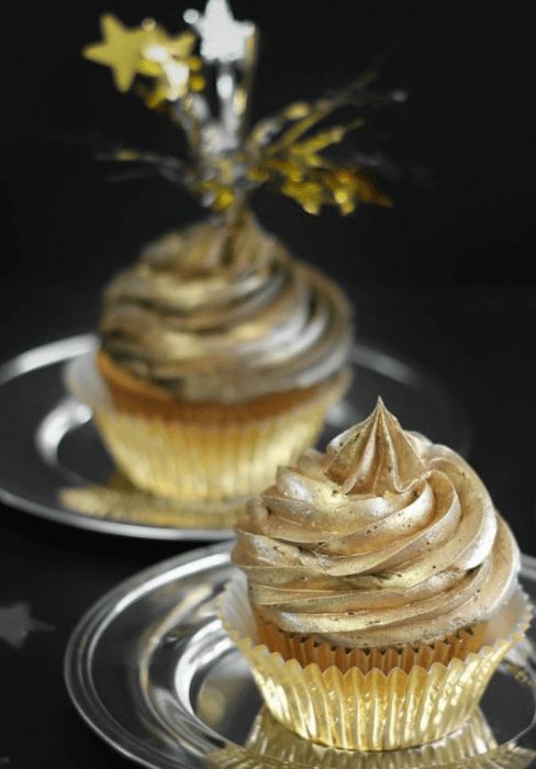 two cupcakes sitting on top of silver plates