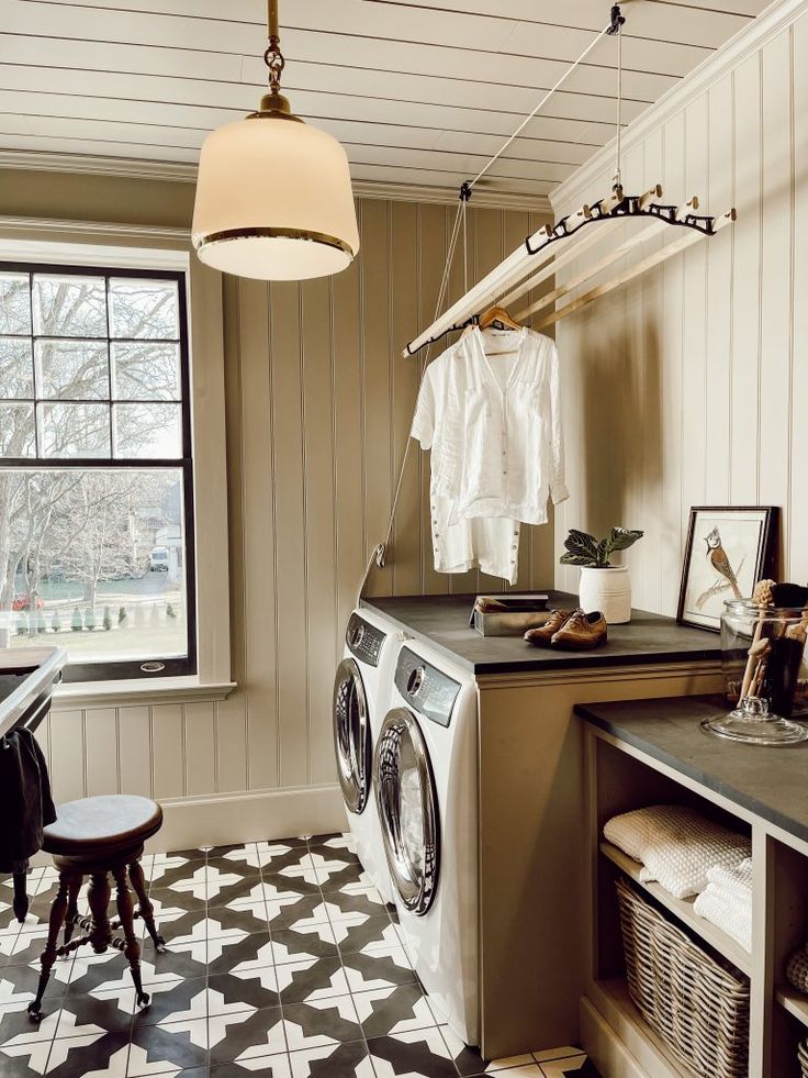 a washer and dryer sitting in a room next to a table with chairs