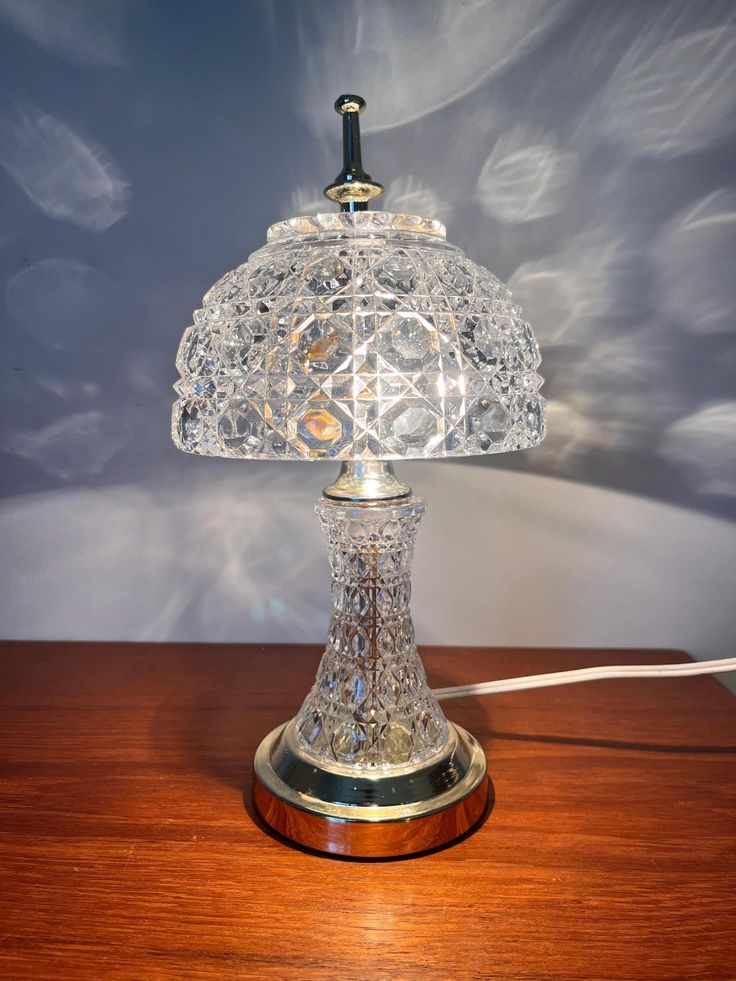 a glass lamp sitting on top of a wooden table