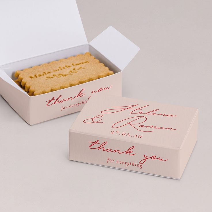 two wedding cookies in a box with thank you written on the top and bottom side