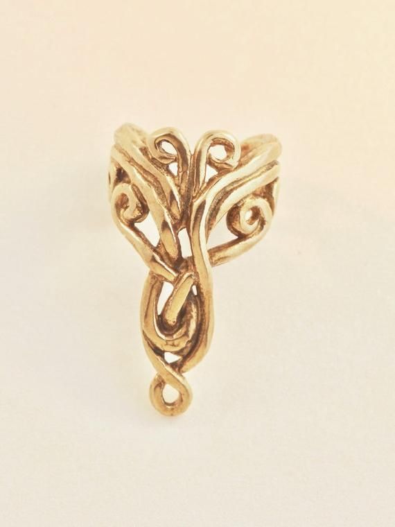 The intricate design of this 14K gold Arabesque Ear Cuff is both classic and exotic. The Arabesque Ear Cuff is 7/8" long, comfortable and easy to wear and it fits both the left and the right ears.  Diamond not included.  Our ear cuffs require no piercings. Starting near the top of the ear, simply slide the cuff down along the edge of the ear's cartilage. If minor adjustments are needed, you may gently open or close the opening of the ear cuff to accommodate the thickness of your ear using a pair Elegant Hand Forged Toe Ring, Gold 14k Ear Cuff For Anniversary, Elegant Spiral Single Ear Cuff, Elegant Adjustable 14k Gold Ear Cuff, Elegant Hand Forged Toe Ring Jewelry, Gold 14k Wedding Ear Cuff, Adjustable Gold Ear Cuff For Anniversary, Elegant Spiral Jewelry With Unique Design, Unique Gold Ear Cuff