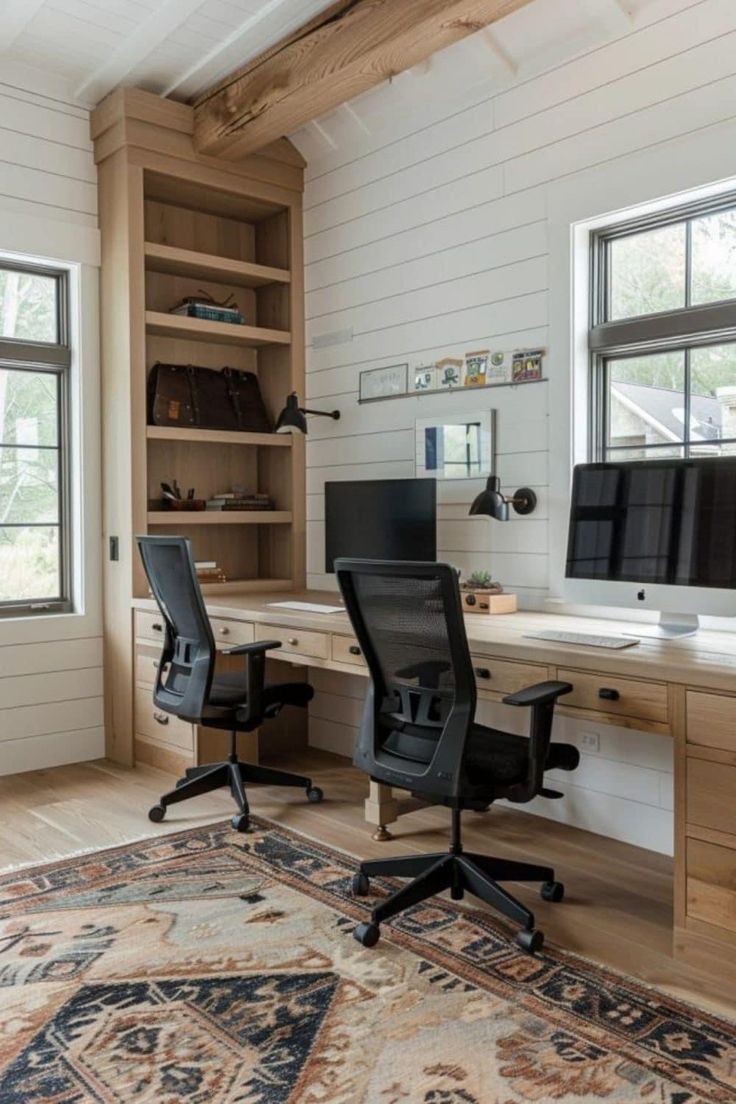 a home office with two computer screens on the desk and an area rug in front of it