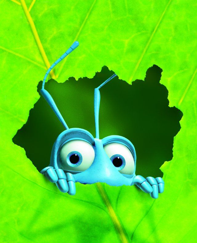 a blue bug with eyes sitting on top of a green leaf