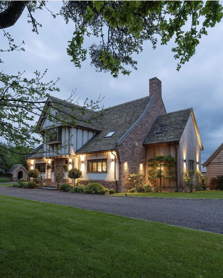 a large house that is lit up at night with lights on the front and side