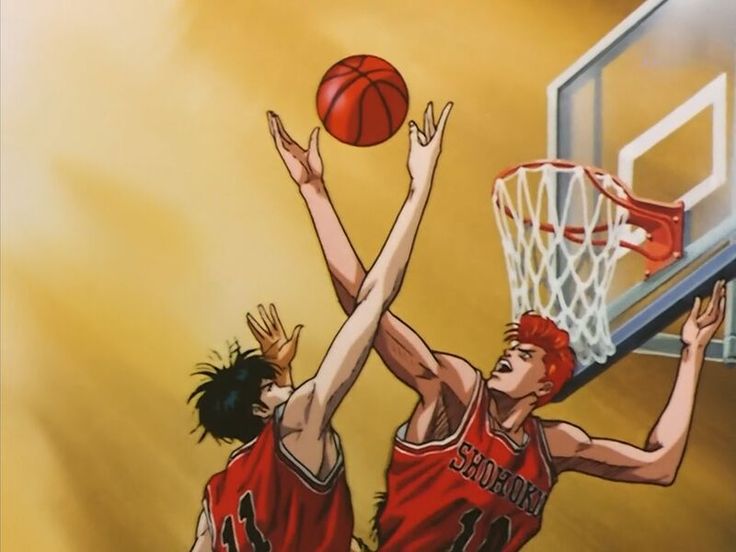 two young men playing basketball against each other in an indoor court with chinese characters on it