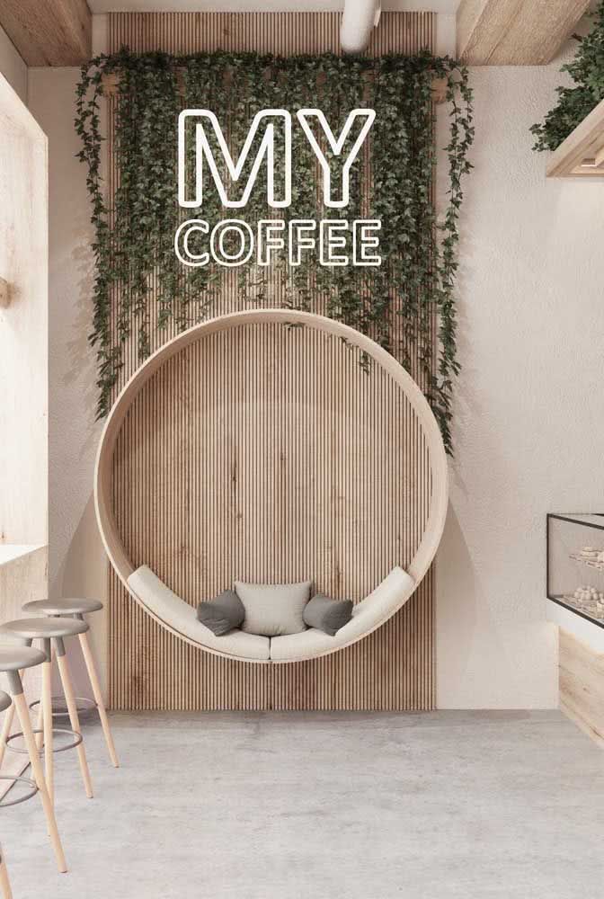 the interior of a coffee shop with plants growing on the wall and round seating area