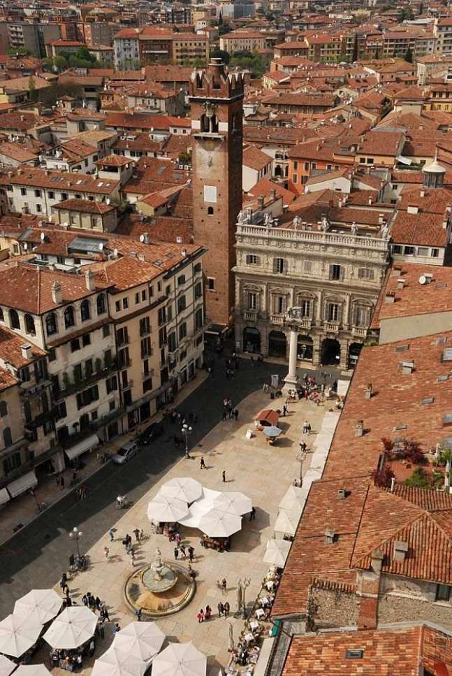 an aerial view of a city with many buildings and people walking around the courtyards