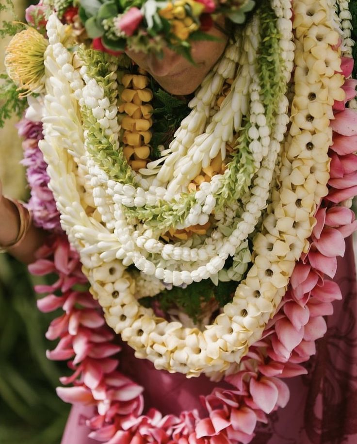 a woman with flowers on her head and scarf around her neck