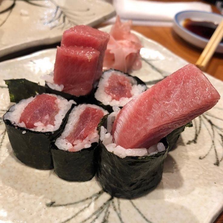 sushi on a plate with chopsticks in the middle and watermelon garnishes